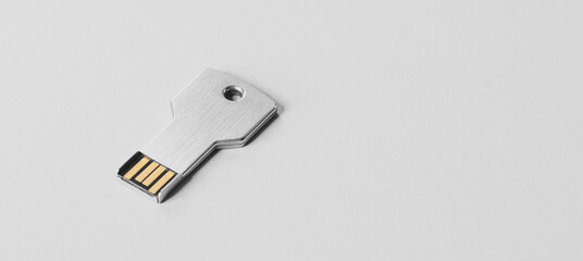 USB flash drive in the form of a metal key. White banner with usb flash memory in the form of a...