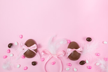 Colorful Easter chocolate eggs, flat lay on pink background. Happy Easter. Stylish Easter layout. Greeting card or banner template