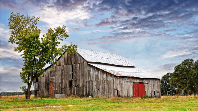 Rural countryside farm landscape with aging barn 