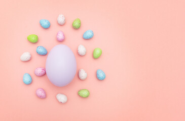 Easter egg with decorative colored eggs on a pink background