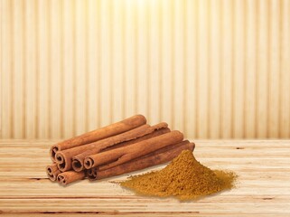 Cinnamon sticks and heap of powder on desk