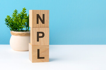 npl - word from wooden blocks with letters, blue background. copy space available