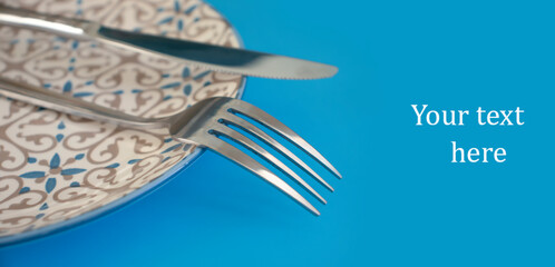 fork, knife, empty plate on a colored background