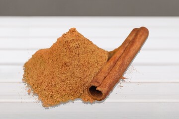 Cinnamon sticks and heap of powder on desk
