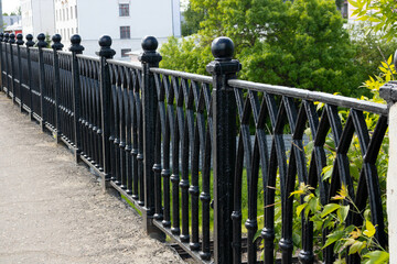 Black forged fence on a granite base