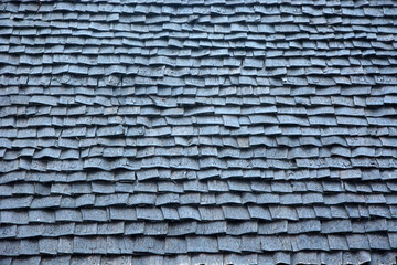 Old wooden shingles on the roof of a house as a background or texture