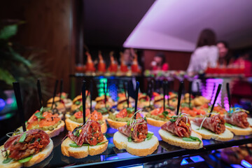 Decorated catering banquet table with different food snacks and appetizers with sandwich