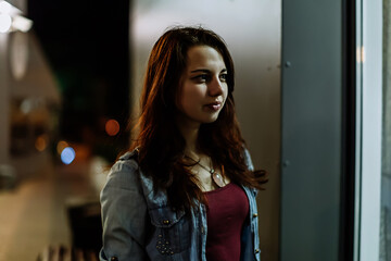Portrait of a beautiful young woman on the street at night bright lights