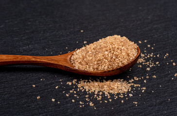 Close-up of a wooden spoon with brown cane sugar.