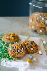 Oatmeal cookies with chocolate eggs surrounded by Easter grass