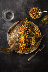 flounder baked with vegetables on a black background