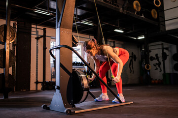 A woman trains on arms exercise machine in the gym