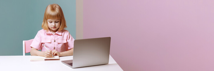 Little joyful girl sitting at a laptop