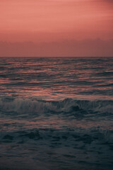 Fototapeta na wymiar Sea with waves and orange sky during sunset
