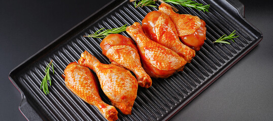 Raw Marinated chicken meat leg swith spices for cooking for BBQ dark background. Top view.Convenience food, precooked.