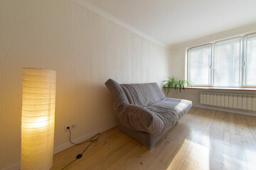 room interior with wooden floor and gray sofa, lamp night light.