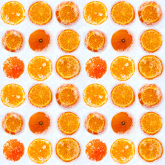 Slices of fresh orange tangerine fruit cowered with white cold winter snow seamless pattern. Bright...