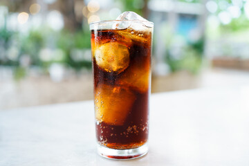 Close up shoot with copyspace of cola soda with ice in a drinking glass. Sparkling cola filled in the glass with ice.
