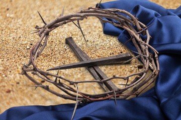 Christian crown of thorns with metal nails on a wooden desk