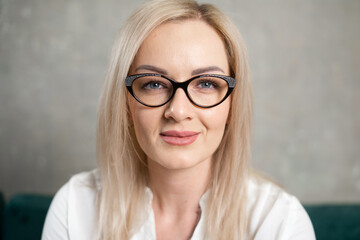 Caucasian beautiful woman in glasses on grey background . Businesswoman portrait