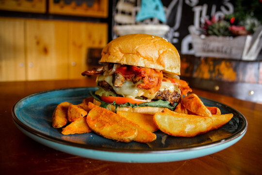 Juicy hamburger on plate and rustic background