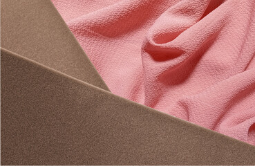 stacks of brown foam sheet material arranged crosswise against a wavy pink fabric background....