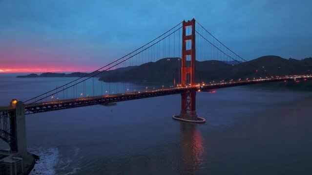 Cinematic night scene of sunset behind car traffic on red Golden Gate Bridge