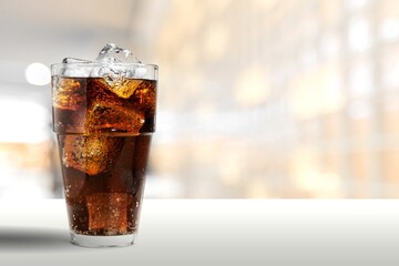 caramel drink, no cola, with ice. Fresh cold sweet drink with ice cubes on red background.