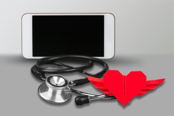 Online doctor concept. Phone with  stethoscope and red heart