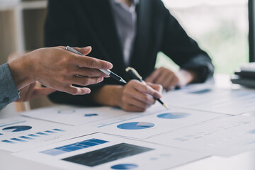 Image of two young business team writting notebook and graph financia at meeting.Close up business team analysis and strategy concept.