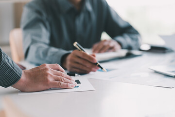 Close-up of businesswomen sitting at the table and discussing business contract during business meeting