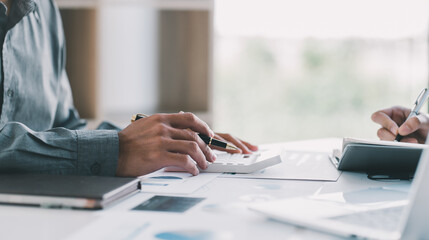 Two business people discuss meeting targets sitting at the business table with documents