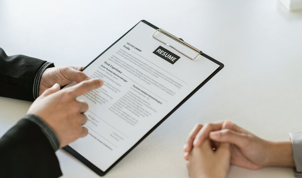 Close up businessman hands holding pen with document at meeting. Man making decision on business deal. Good business partners negotiation at job interview in office.