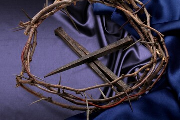 Christian crown of thorns with metal nails on a desk
