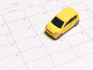 Miniature car on blank calender. Loan payment or maintenance schedule concept.