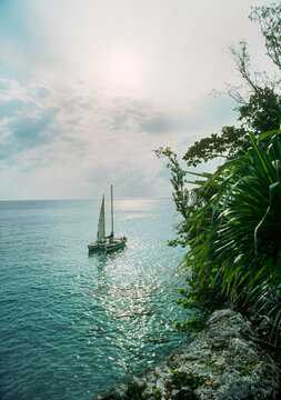 Catamaran sailboat anchored at West End cliffs, Negrill, Jamaica, WI.