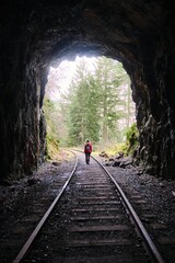 Woman walking through railway tunnel. Goldstream Park. Galloping Goose trail. Vancouver Island....