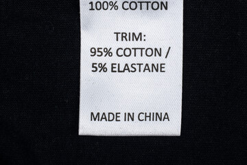 Made in china clothes label on a black background. 100% Cotton Clothing.