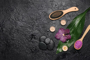 Spa composition with aroma candles, sea salt, hairbrush and stones on dark background