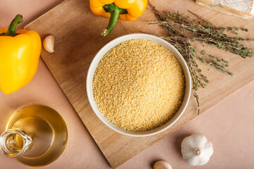 Bowl of raw couscous on table