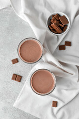 Glasses of delicious chocolate milk on grunge background