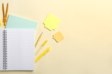 Blank notebook and stationery on yellow background