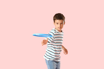 Funny little boy playing frisbee on color background