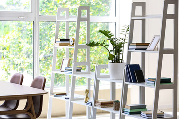 White book shelves with houseplant in light room