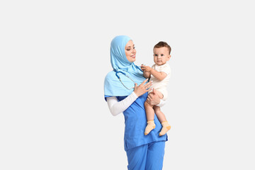 Muslim pediatrician with baby boy on light background