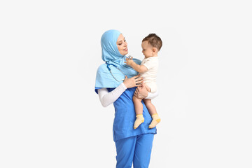 Fototapeta premium Muslim pediatrician with baby boy on light background
