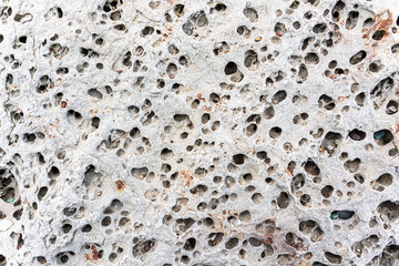 texture of porous stones on the beach, nature, natural phenomena, brown gray stones - obrazy, fototapety, plakaty