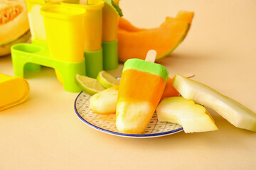 Tasty popsicles and melon pieces on beige background