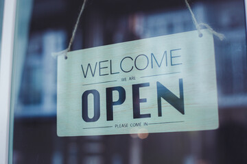 Text  "Welcome Open" on cafe or restaurant hang on door at entrance.