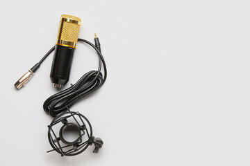 Modern microphone with stand on light background